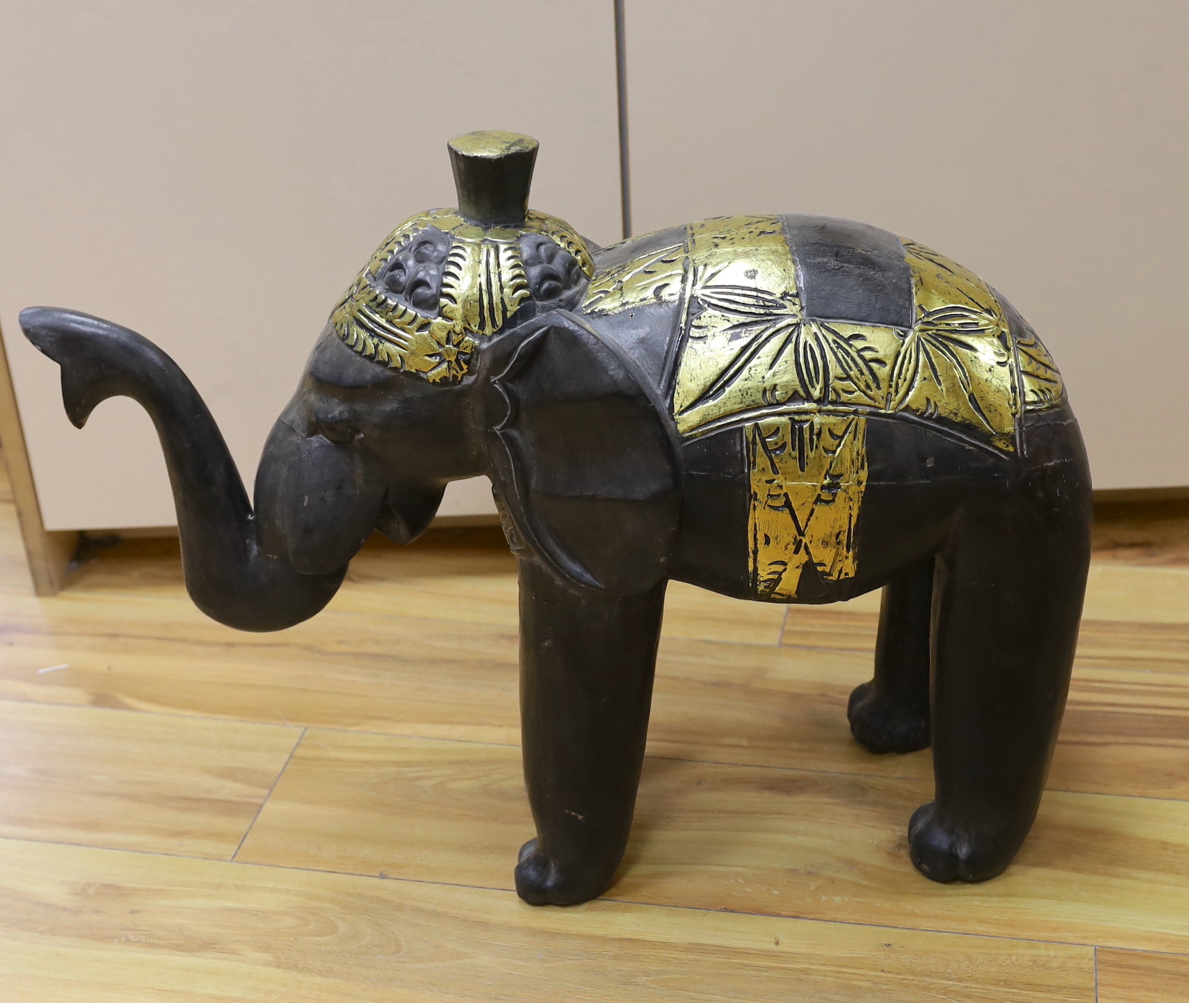 A carved Indian elephant, decorated with gilt decoration, 49cm high